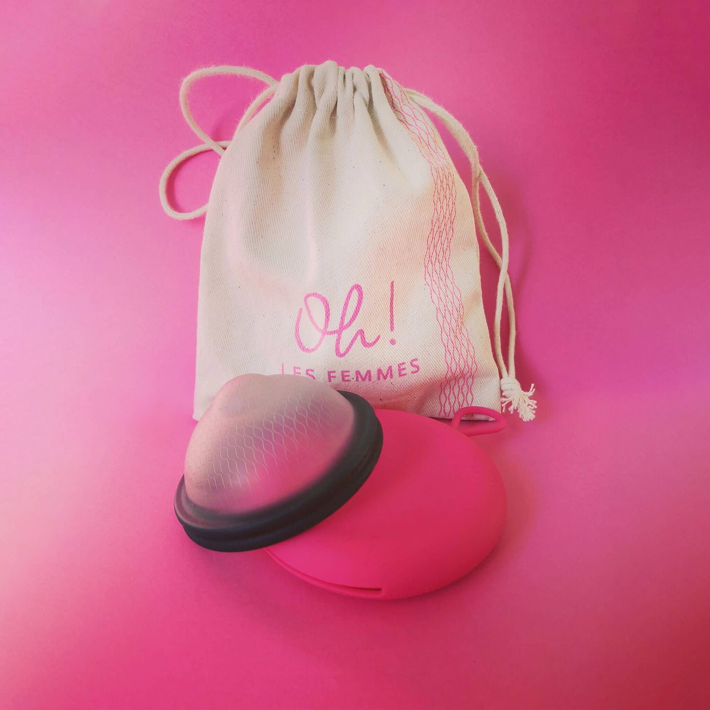 Le disque menstruel réutilisable noir discoh taille L, sa pochette en silicone fuchsia, avec son pochon en coton logo imprimé. Alternative aux tampons et serviettes.